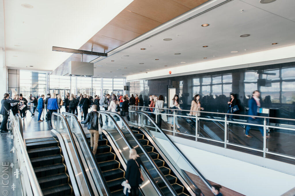 Group of delegates and visitors circulating in foyer 4 during a convention.