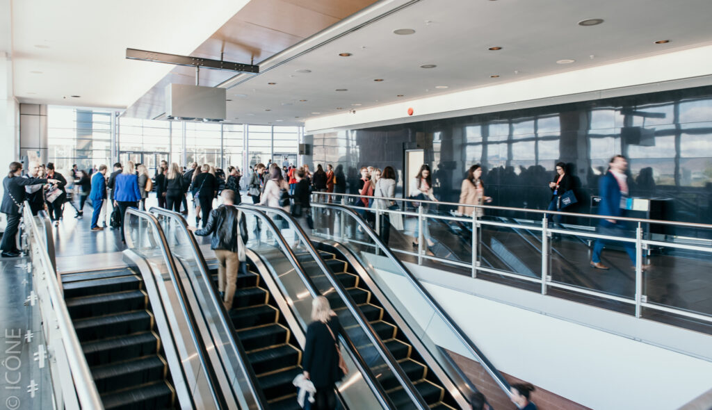 Groupe de congressistes et de visiteurs circulant dans le Foyer 4 et dans les escaliers roulants durant leur congrès.