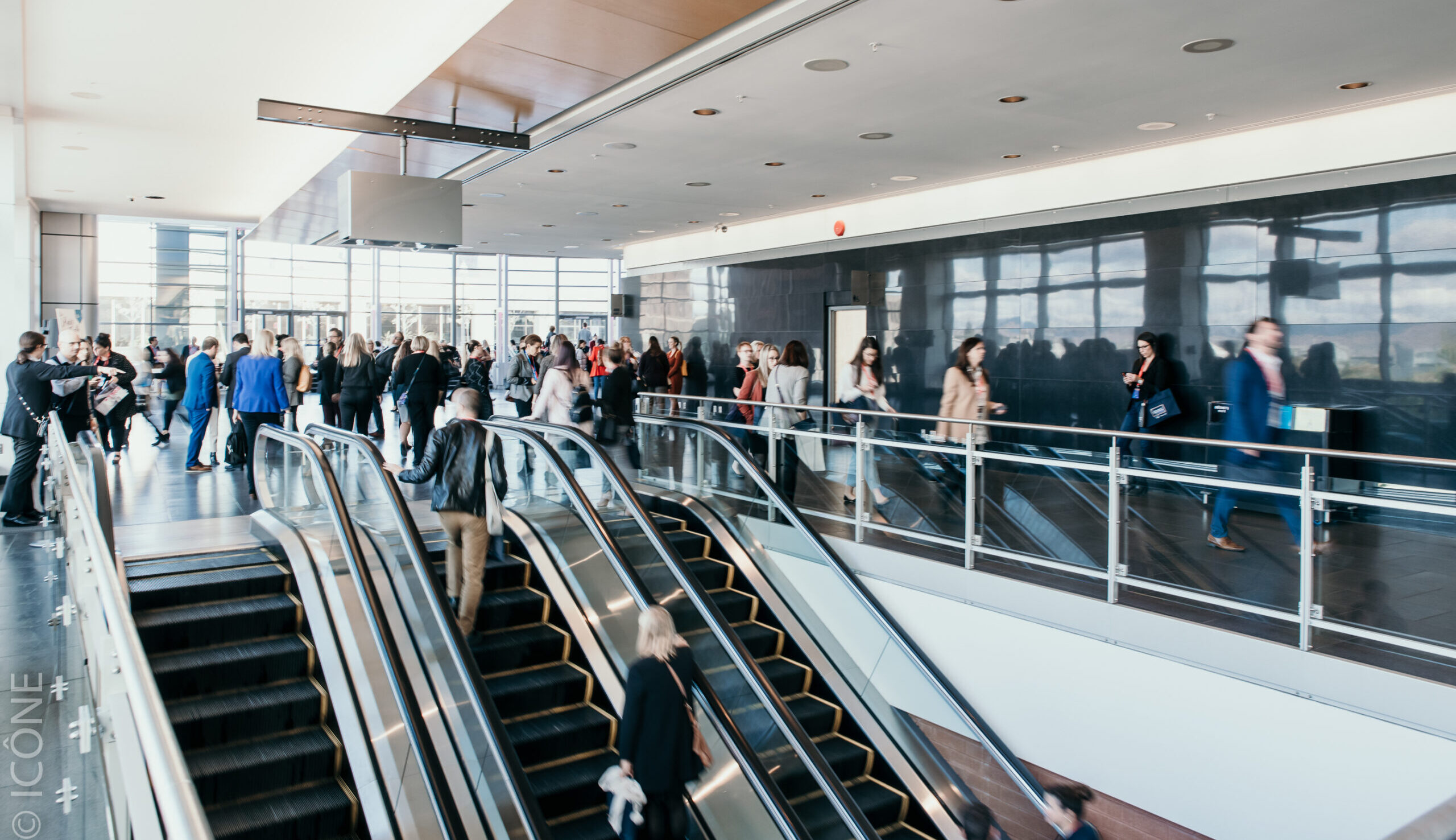 Group of delegates and visitors circulating in foyer 4 during a convention.